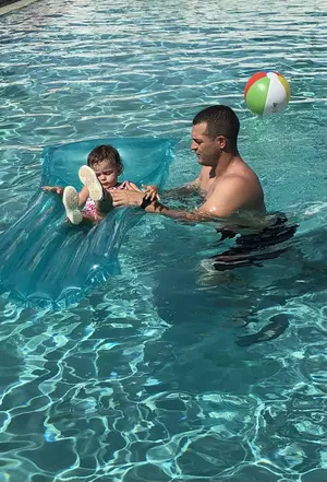 Father Child Floating In Ground Pool Ball Ground