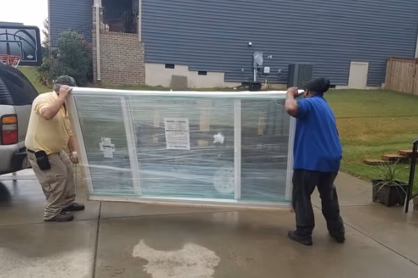Two Workers Carrying Replacement Window